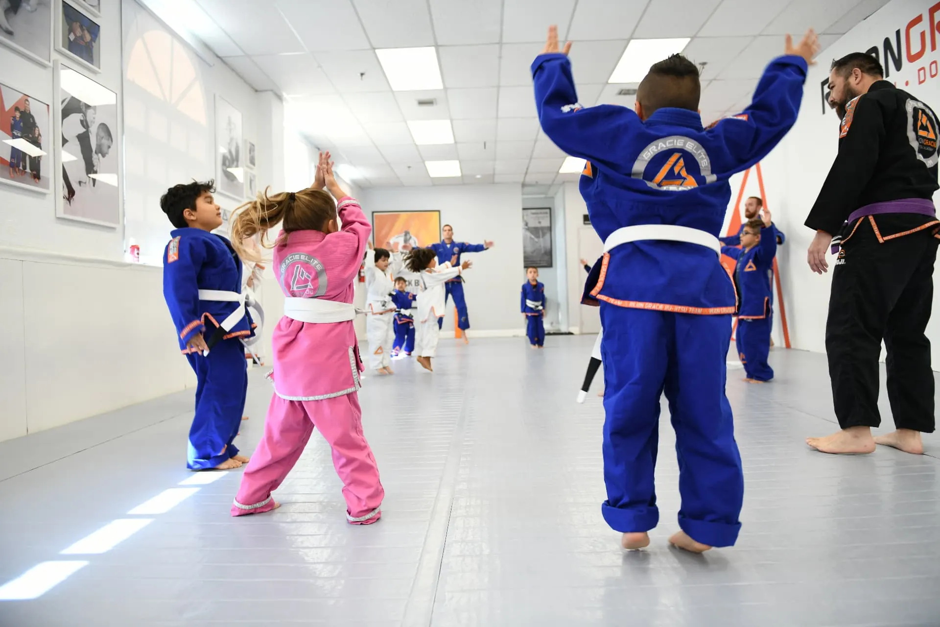 Kids raising their hands during a Jiu-Jitsu class at Rilion Gracie Doral